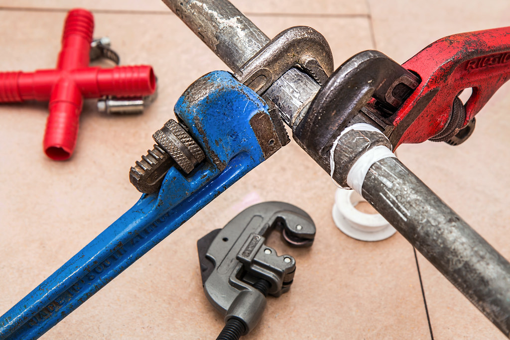 Plumbing tools on a tile floor
